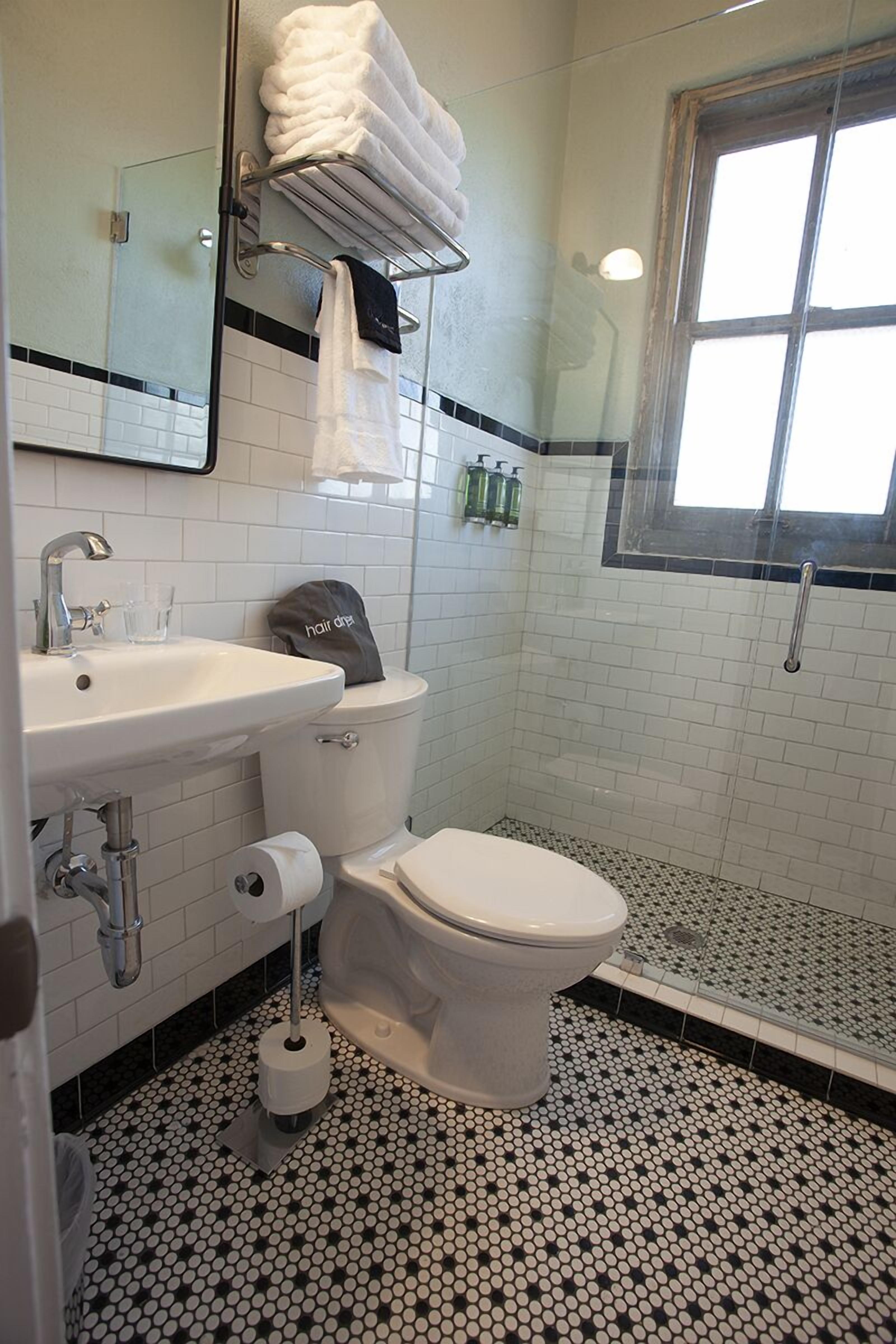 Une salle de bain avec des toilettes, un lavabo et une douche.