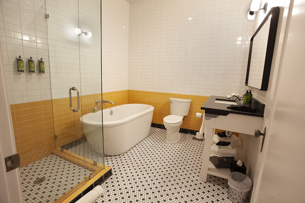 A bathroom with a bathtub, toilet, and glass-enclosed shower.