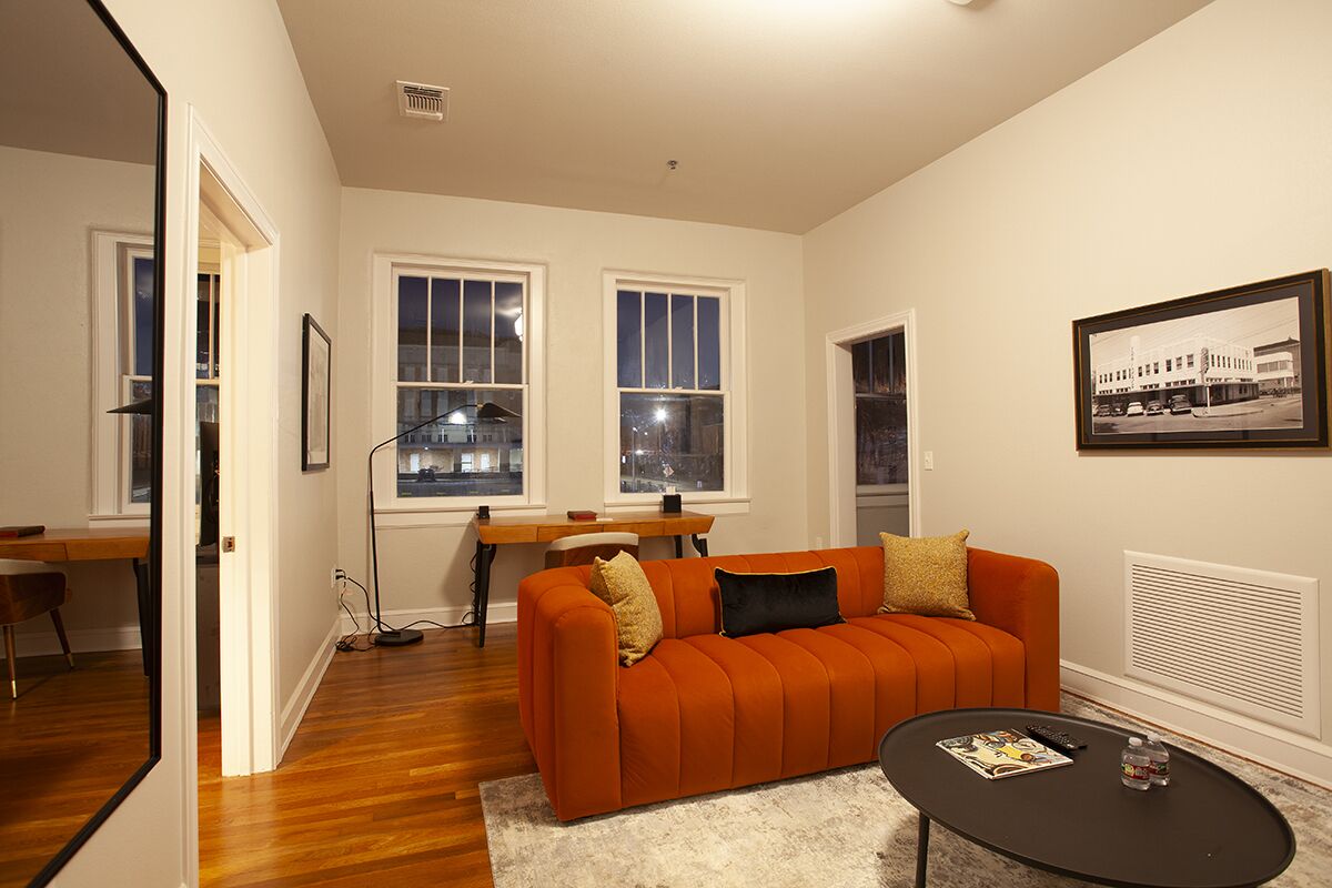 A living room with a sofa, coffee table, and framed picture on the wall.