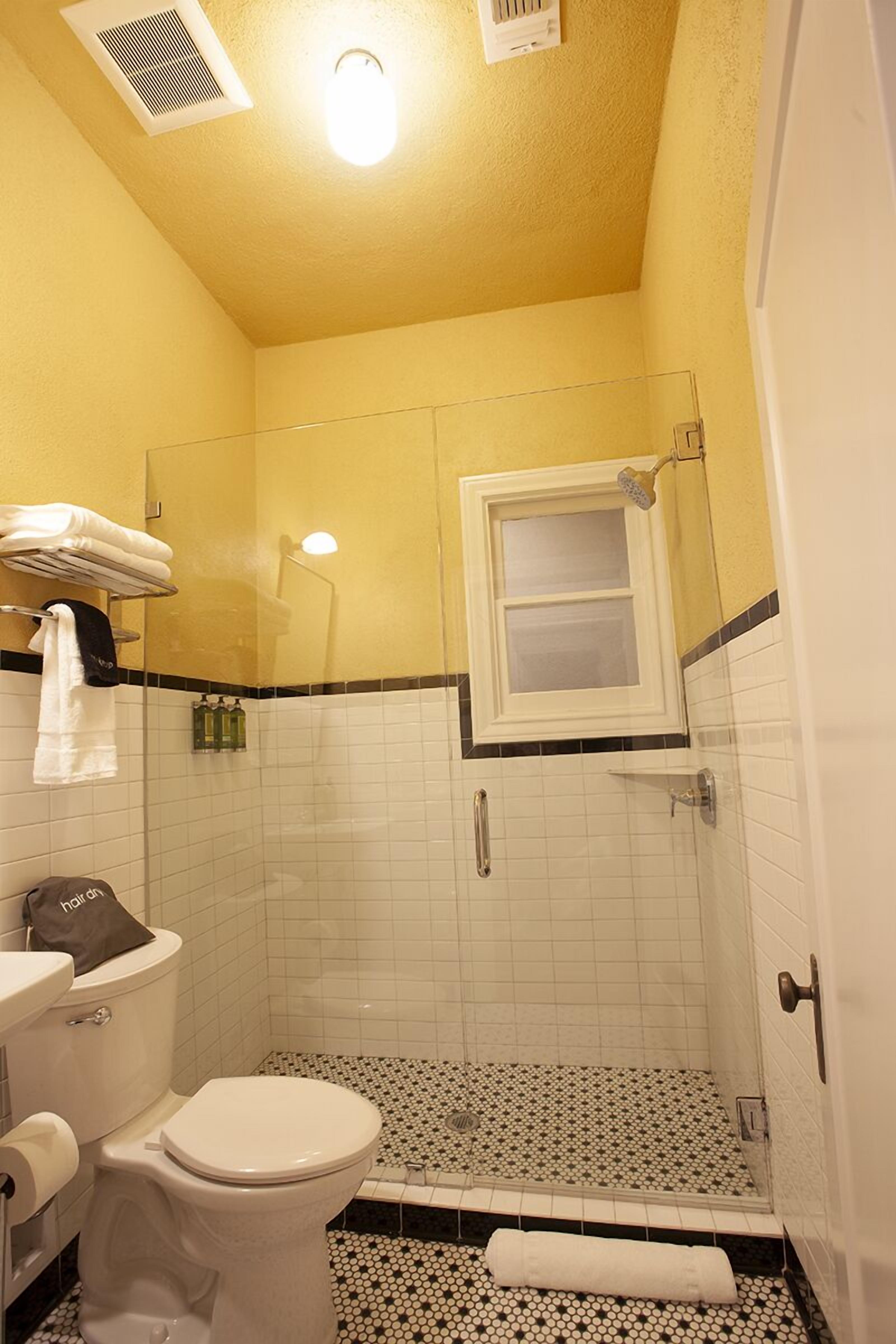 A bathroom with a toilet, a shower, and a sink.