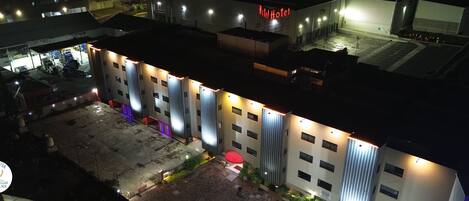 Un hotel con fachada moderna, varios balcones y una zona de entrada bien iluminada.