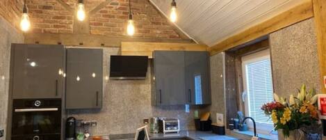 A modern kitchen with granite countertops, stainless steel appliances, and a large island with a chalkboard menu.