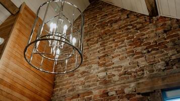 A room with exposed brick walls, wooden paneling, and a hanging light fixture.