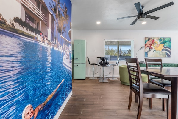 Une pièce avec une piscine, un coin repas et une cuisine.
