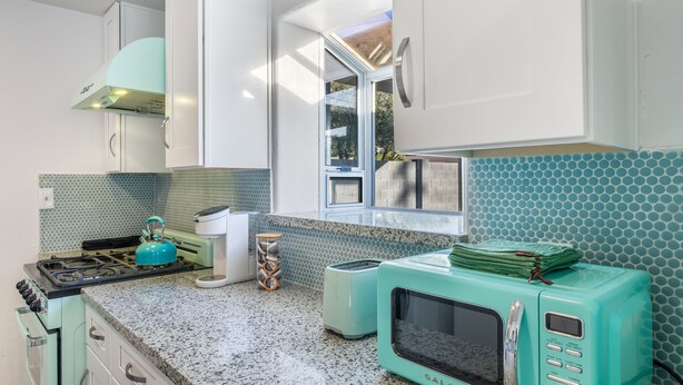 A kitchen with a gas stove, a microwave, and two toasters. - Biltmore Boho Bungalow w/Heated Pool, Fenced Yard, AC, W/D, Fast Wifi, Smart TVs (Phoenix)