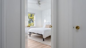 A bedroom with a bed, a window, and a ceiling fan. - Coral House - Waterfront Beach Getaway, Stunning Sunsets, 9 min walk to beach! (Wrightsville Beach)