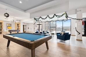 Relax and unwind in our modern lounge area, featuring a pool table and comfortable seating for a leisurely game or social gathering.