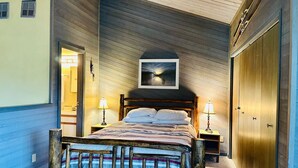A bedroom with a wooden bed, bedside lamps, a framed picture on the wall, and a wardrobe. - Apex Mountain ~ The Powderhorn (Hedley)