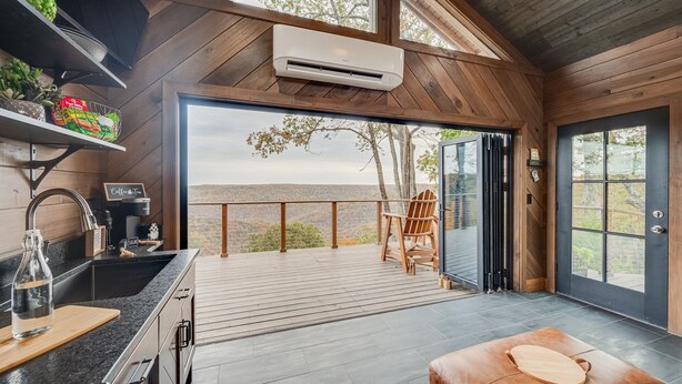 A modern kitchen with a large island, a coffee station, and a view of the mountains. - Hidden Mountaintop Getaway (Scottsboro)
