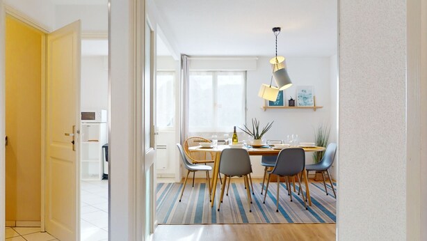 A modern dining area with a wooden table, chairs, and a striped rug. - Elegance, appartement 6 pers.+ parking (Colmar)