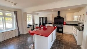 Une cuisine moderne avec un îlot central, des armoires blanches et une cuisinière noire.