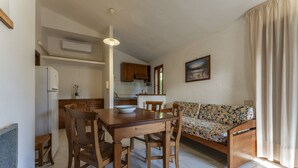 A compact living space with a dining area, kitchenette, and a sofa. - Apartment in Giannella with 2 bedrooms sleeps 4 (Giannella)