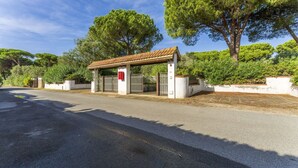 A gated entrance with a small covered waiting area, surrounded by lush greenery and trees. - Apartment in Giannella with 2 bedrooms sleeps 4 (Giannella)