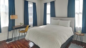 Ein Schlafzimmer mit einem großen Bett, einem Schreibtisch und einem Stuhl.