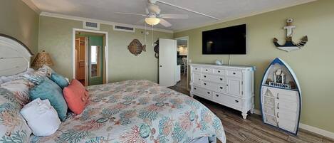 A bedroom with a bed, dresser, television, and nautical-themed decor.