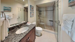 Un bagno con doppio lavabo, un water, una doccia con box in vetro e una cabina doccia.