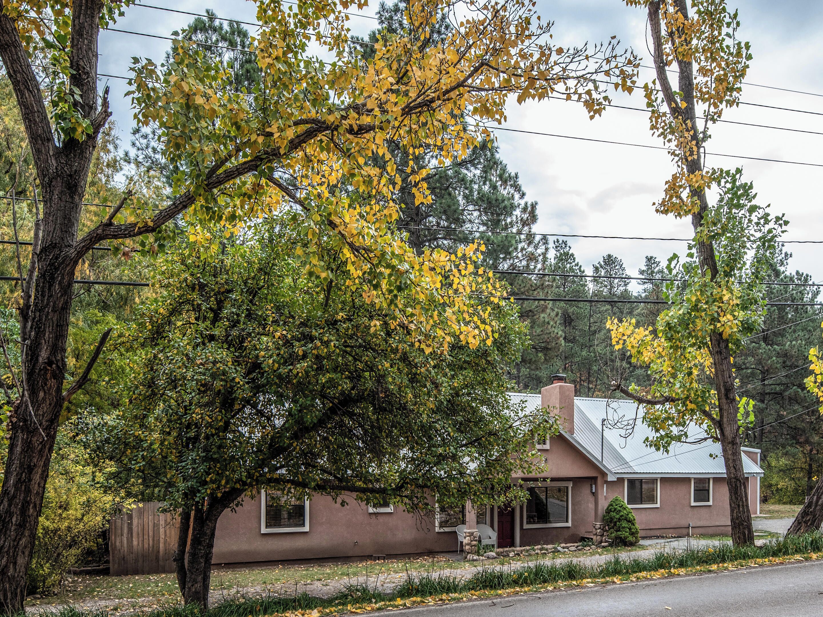 A two-story house with a brown exterior, a front porch, and a visible chimney.