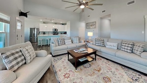 A living room with a sofa set, a coffee table, and a patterned rug. - Mambo's Grill by Miss Kitty’s (Rockport)