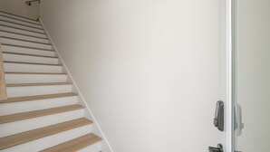 A staircase with wooden steps and a white wall.