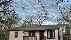 Une maison de plain-pied avec un porche à l’avant et un petit jardin devant.