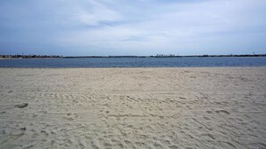Une vaste plage de sable fin, avec une mer calme et un ciel dégagé.