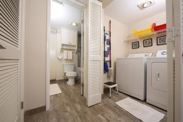 Une petite salle de bain comprenant des toilettes, un lave-linge et un petit marchepied.