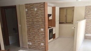 Una cocina moderna con una isla central, armarios empotrados y un ventanal con persianas.