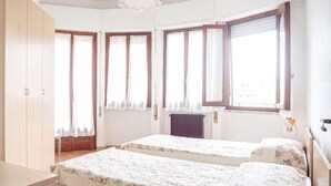 Una habitación con dos camas, un armario y un radiador.