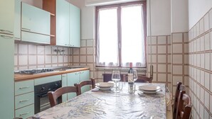 Eine kompakte Küche mit Essbereich, ausgestattet mit einem Herd, Backofen und einem Tisch für zwei Personen.