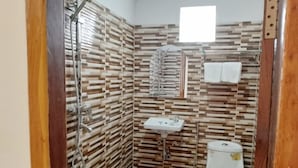 A small bathroom with a shower, sink, and toilet. - PL Villa (Siem Reap)
