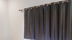 A room with two single beds, white bedding, a dark curtain, and a white wall. - PL Villa (Siem Reap)