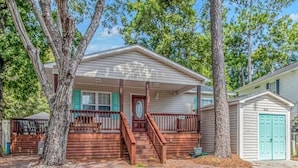 A single-story house with a front porch, a staircase leading to the entrance, and a garage.