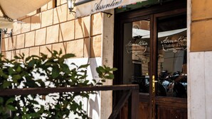 Una fachada con un letrero que dice "Assuntina" y una puerta de madera.