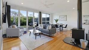 A modern living room with a sofa, coffee table, and fireplace.