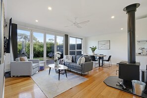 Ein geräumiges Wohnzimmer mit Sofa, Couchtisch und Kamin.