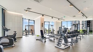 Uma academia moderna com equipamentos de cardio, estações de musculação e pesos livres.