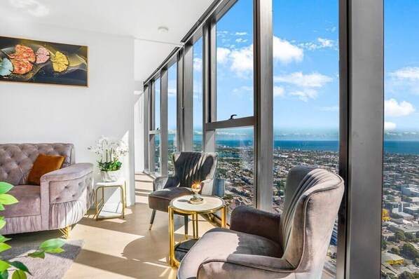 A spacious living room with a large window offering a city view.