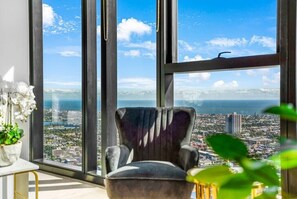 A room with a large window offering a cityscape view.