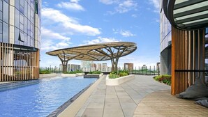 Un espace piscine sur le toit, doté d’une architecture moderne, comprenant une structure de toit originale et une terrasse en bois.
