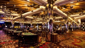 A casino with multiple blackjack tables, chandeliers, and a patterned carpet. - Breathtaking Views 49th floor - Melbourne Square (Southbank)