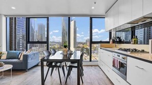 Una cucina moderna con un'ampia finestra, una zona pranzo con tavolo e sedie, e un divano.