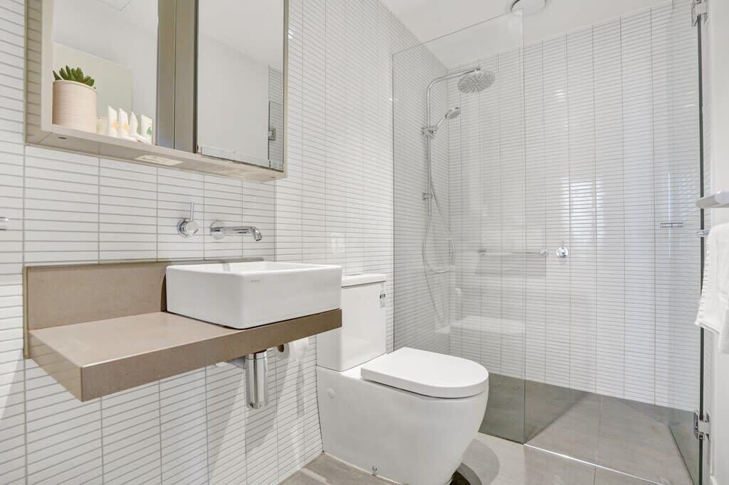 Ein modernes Badezimmer mit Toilette, Waschbecken und Dusche.