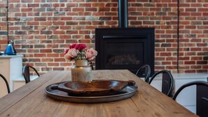 A wooden table with a metal tray and a vase of flowers. - SENSATIONAL Renovated Cottage in Beautiful Seddon (Seddon)