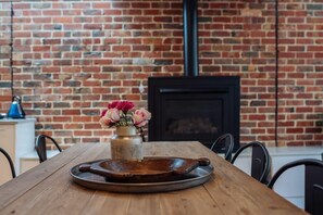 A wooden table with a metal tray and a vase of flowers.