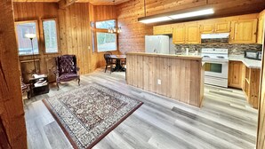 Un interior de madera con comedor, cocina y un tapete.
