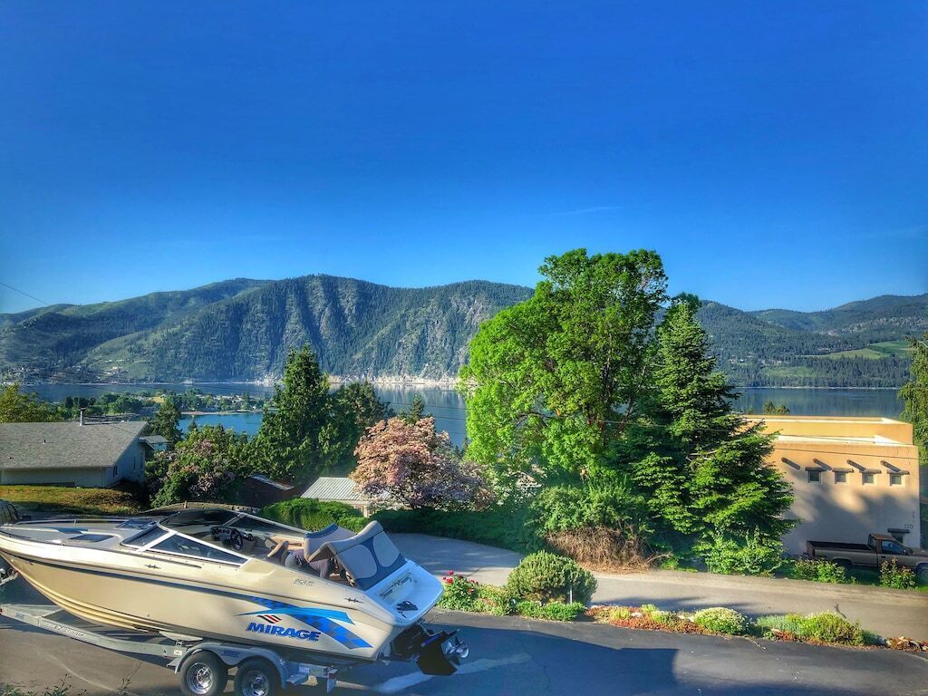 Ein Boot auf einem Trailer vor einer Berg- und Seenlandschaft.