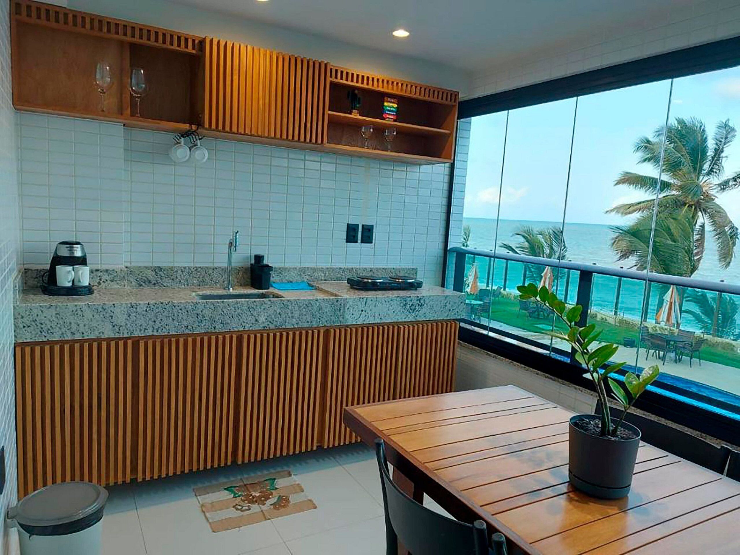 Una cocina moderna con encimera de granito, armarios de madera y vistas al océano.