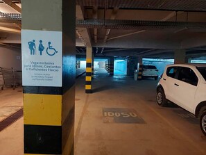 A parking garage with a sign indicating an exclusive parking space for the elderly, pregnant, and physically disabled. - Flat Frente Mar - Praia de Tabatinga (Conde)