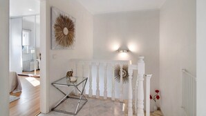 A modern interior with a glass table, white balustrade, and decorative wall art. - Villa 'Alonzo' with Private Pool, Wi-Fi and Air Conditioning (Albufeira)