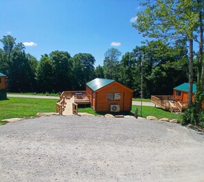 A wooden cabin with a gravel driveway and a picnic table. - 110) Loon Log Cabin. Close to Hocking Hills State Park and more! (Logan)